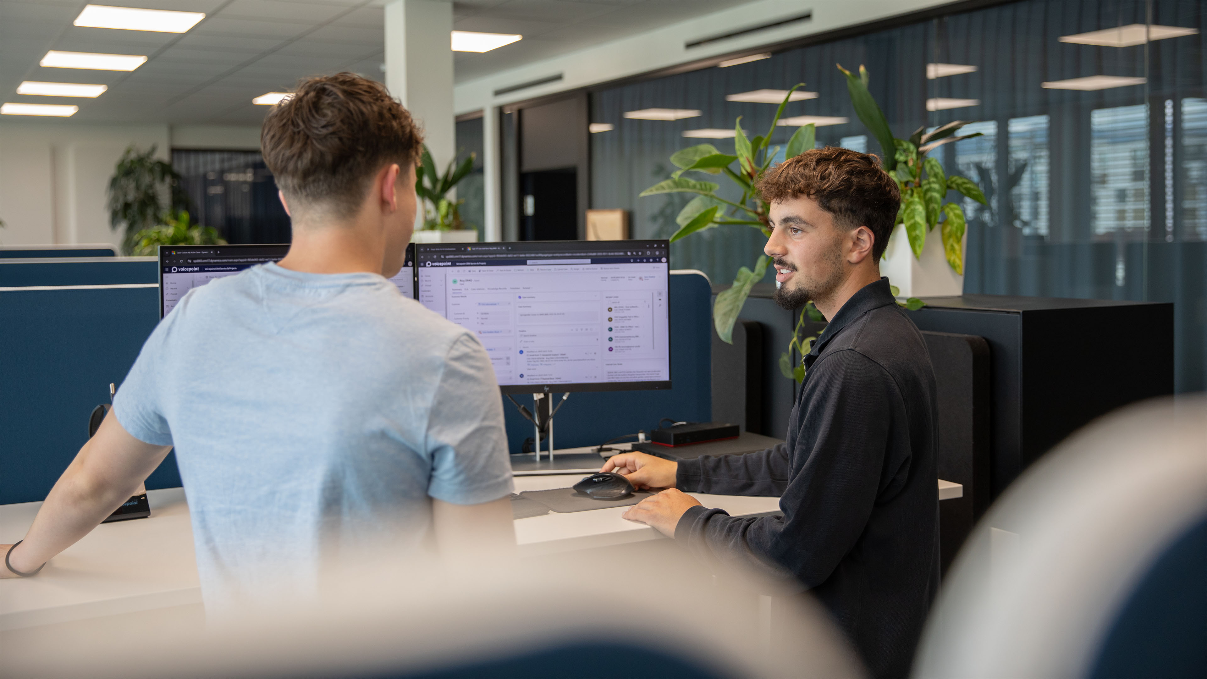 Mitarbeiter bespricht mit einem Informatik-Lernenden ein Projekt am Computer.
