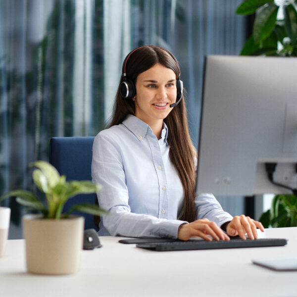 Employee sitting at a computer, wearing a headset and managing dictations with the Voicepoint Xenon Flow solution.